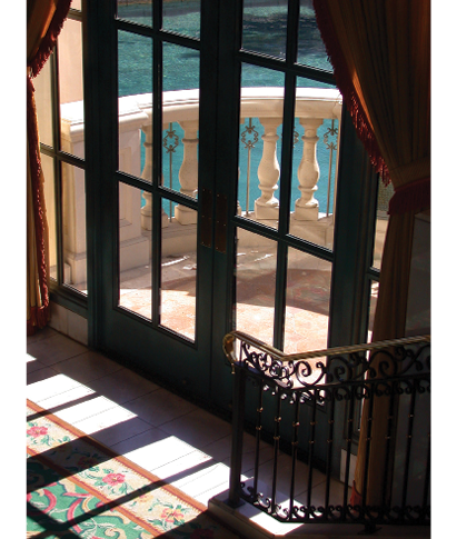Photo of windows looking out on a balcony overlooking the ocean.