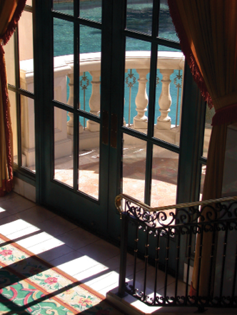 Photo of windows looking out on a balcony overlooking the ocean.