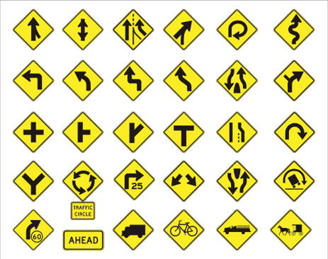 Image of many yellow and black road signs. 
